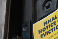 A yellow eviction notice pinned to the front door of a house